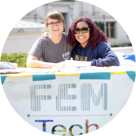 Two students at a Fstrong Tech booth on UC Berkeley campus.