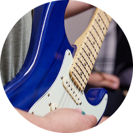 Close-up of person playing guitar.